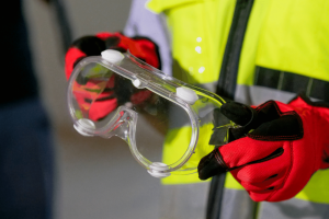 person holding protective glassware and wearing ppe