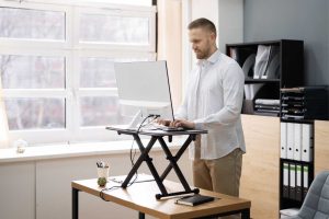 man working on a standing desk at work