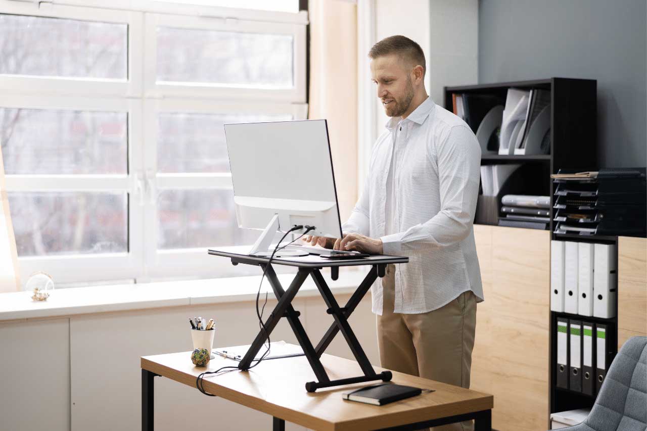 man working on a standing desk at work