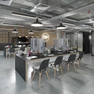Modern industrial office with wooden dark tables with perspex dividers and modern stylish chairs