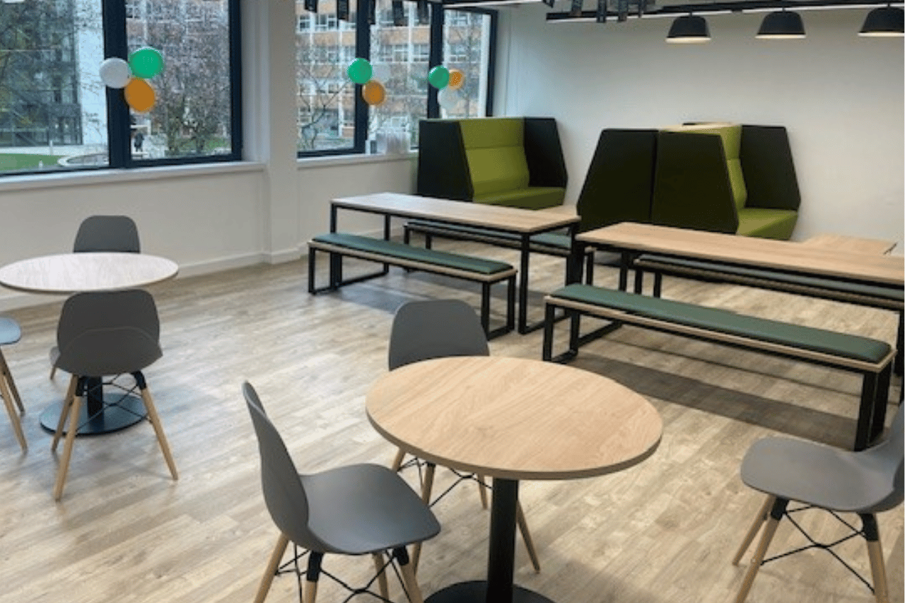 photo of a finished office lounge with tables chairs and modular sofas